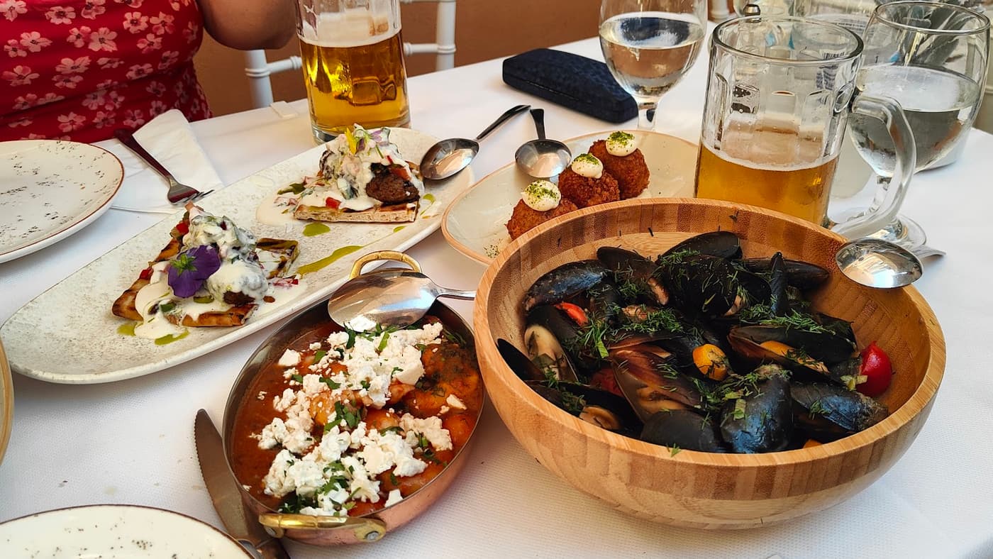 Spread of Greek dishes — mussels, saganaki, fritters